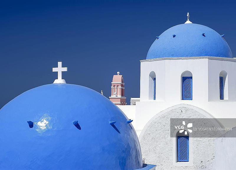 希腊圣托里尼伊亚教堂的蓝色穹顶和钟楼图片素材