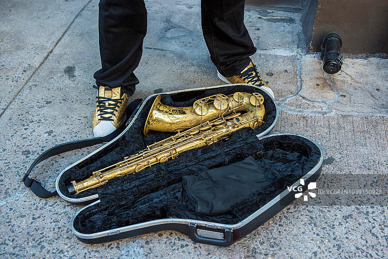炎热夏日黄昏时分纽约街头黑色天鹅绒盒中的萨克斯管和金色运动鞋图片素材