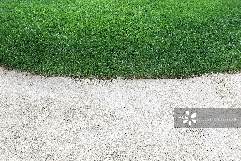 高尔夫球场沙坑边缘特写，有沙子和草图片素材