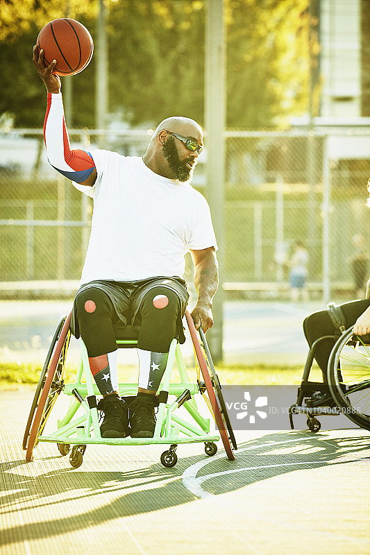 夏季傍晚轮椅篮球比赛中，残疾运动员准备传球图片素材