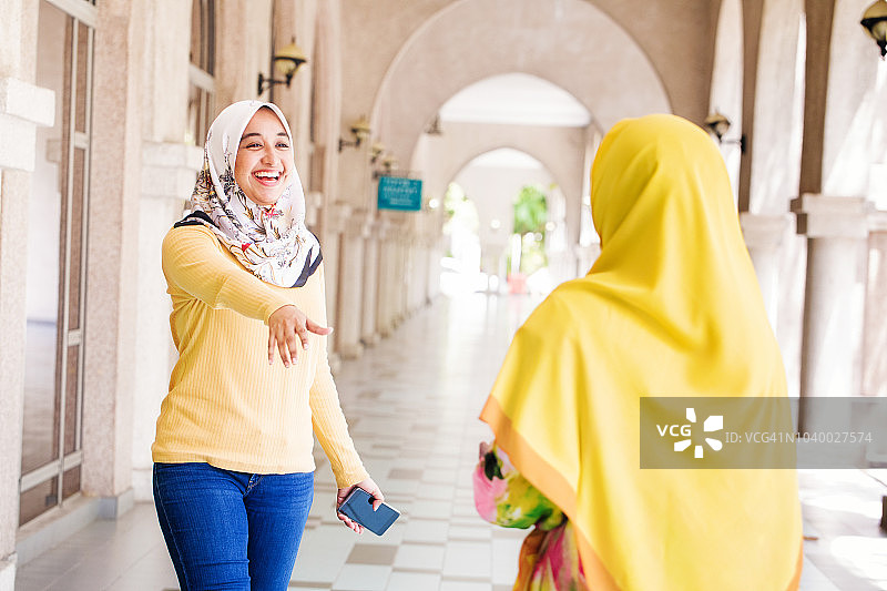 穆斯林女大学生微笑着与朋友打招呼图片素材