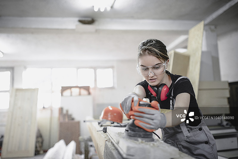 可爱的女人学习如何打磨木板图片素材