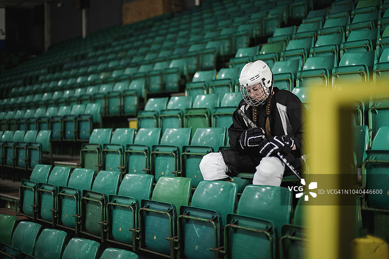 独自坐着的冰球运动员图片素材