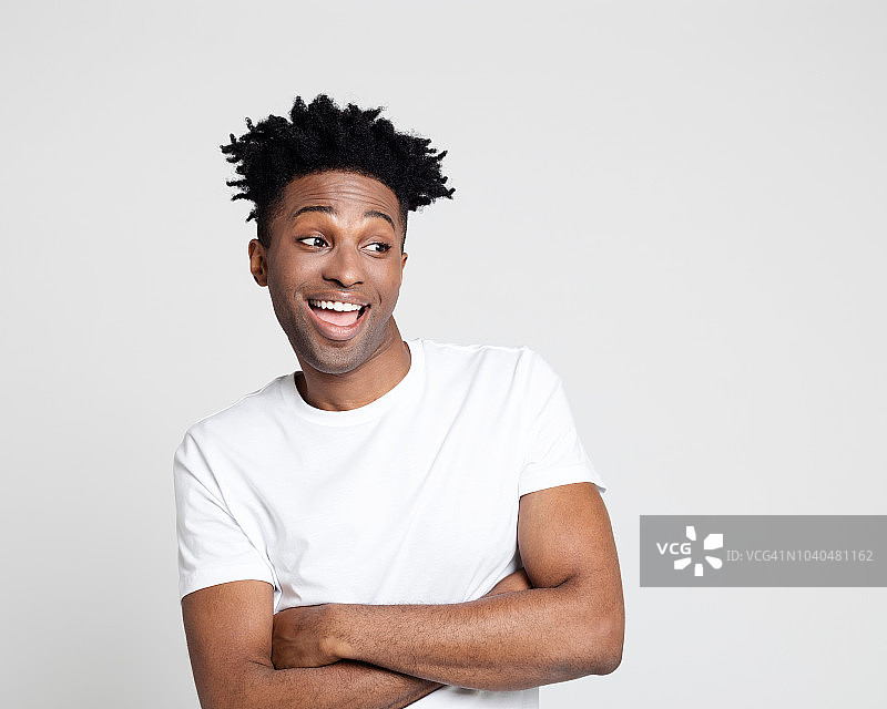 看着空白区域的兴奋的年轻非裔美国男子图片素材