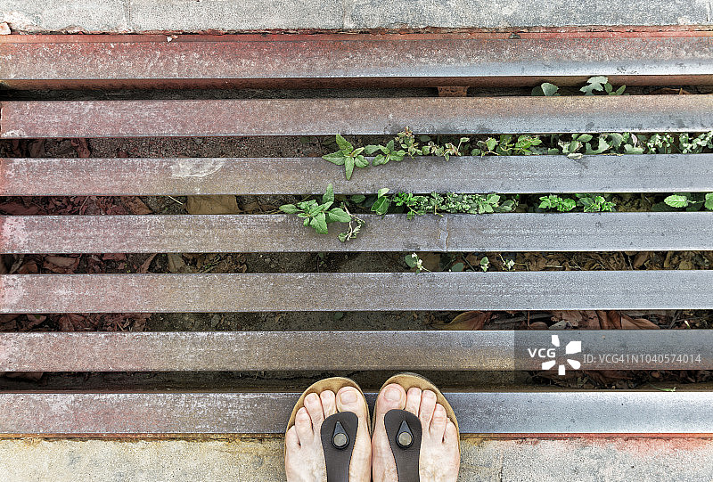 站在方形金属格栅排水盖上的女人的下半身图片素材
