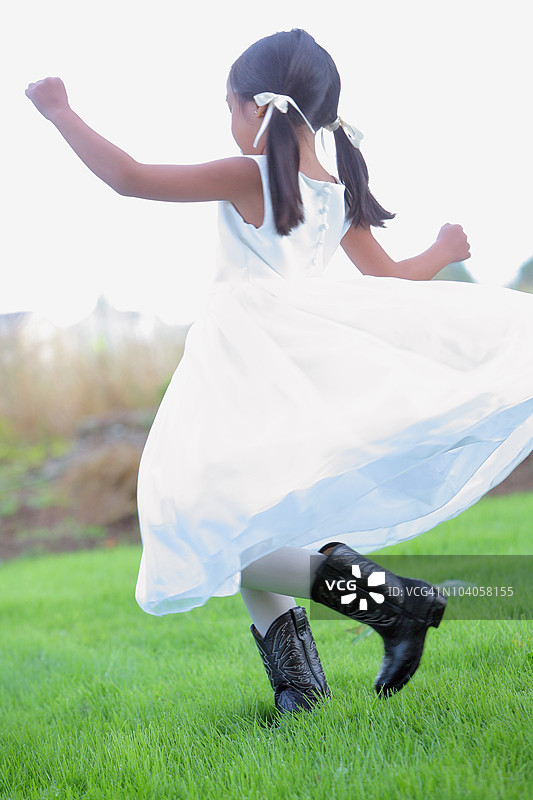 一个穿着白色裙子和牛仔靴的小女孩图片素材