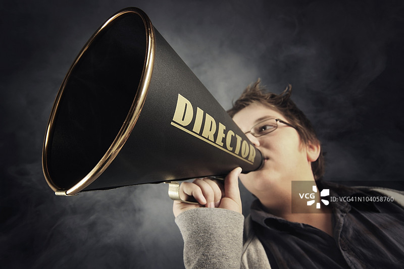 一个拿着标有“导演”的扩音器的男孩图片素材