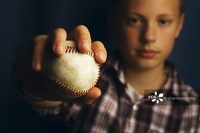 一个男孩拿着棒球图片素材
