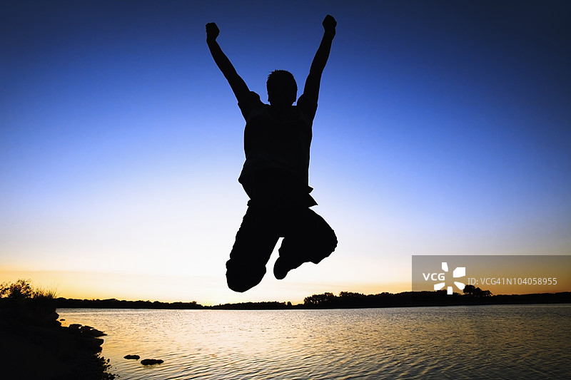 日落时分，水边跳跃的人影图片素材