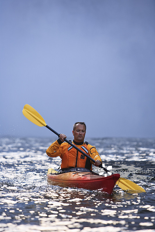 一名男子在斯诺夸尔米瀑布附近划皮艇图片素材