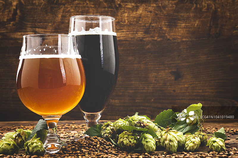 木制背景上的啤酒和啤酒花图片素材