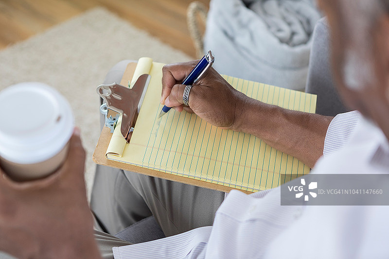 男子在黄色便签本上书写图片素材