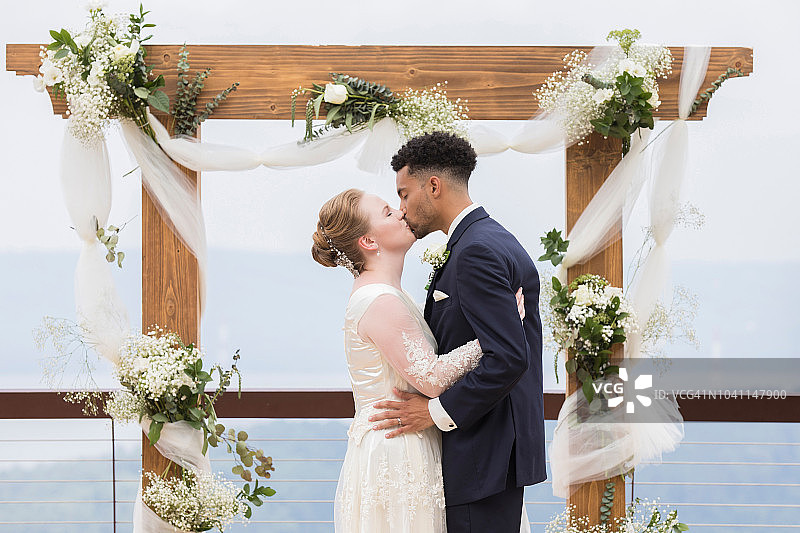 新娘新郎在婚礼圣坛前接吻图片素材