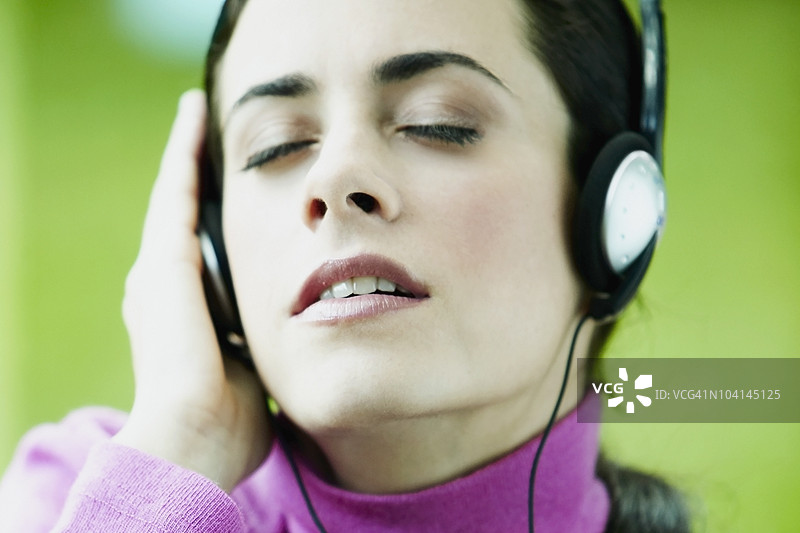 年轻女性专注地听音乐的特写镜头图片素材