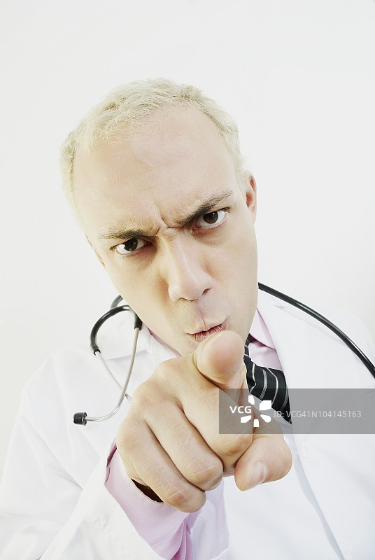 男医生指向前方，面露怒容特写图片素材