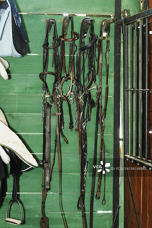 马嚼子和悬挂的马镫在马厩里图片素材