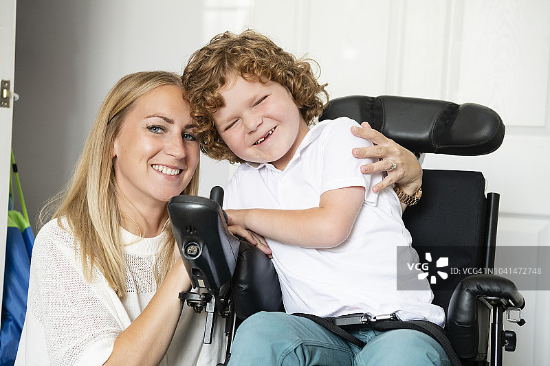 快乐的残疾男孩和他的母亲微笑的肖像图片素材
