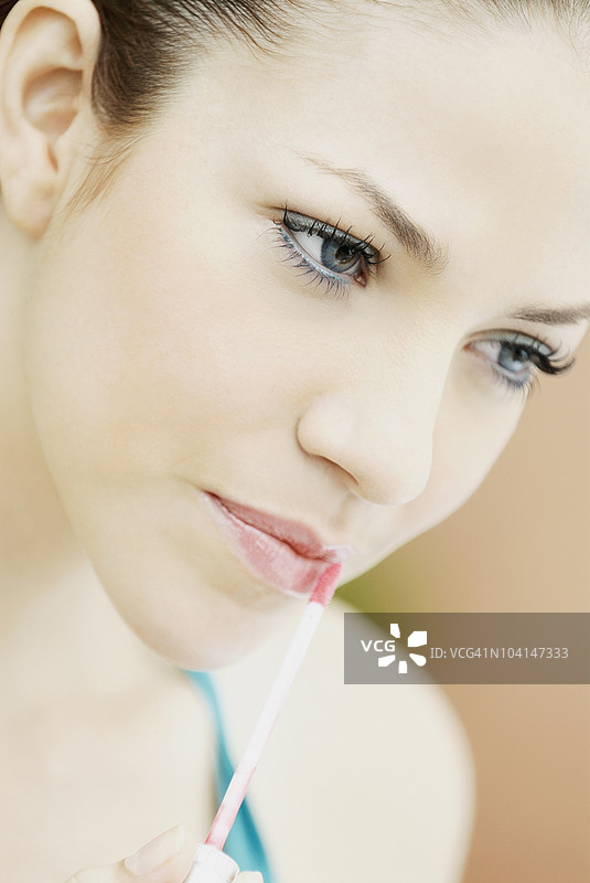年轻女性在涂抹唇线笔的特写镜头图片素材