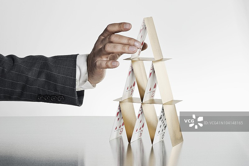 商务人士搭建金色纸牌屋图片素材