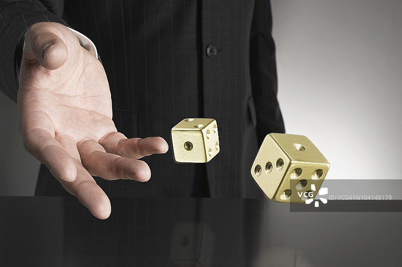 商人滚动金色骰子图片素材