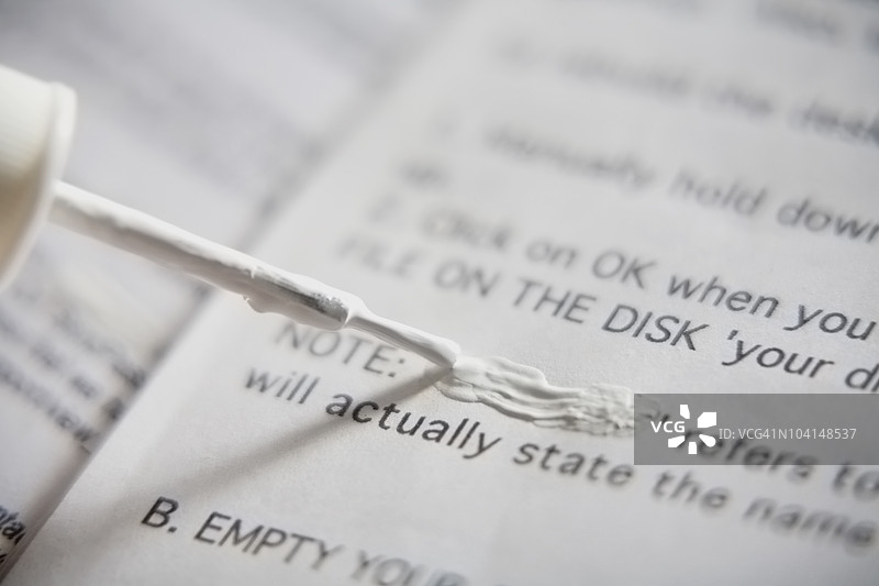 文档上涂抹修正液的特写镜头图片素材