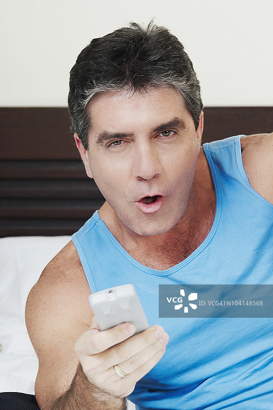 一位男性手持遥控器的肖像图片素材