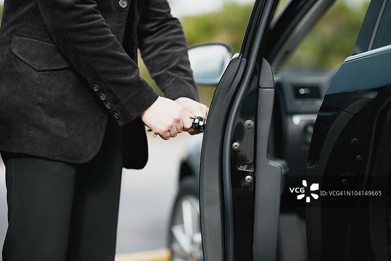 年轻男子打开车门的中段视角图片素材