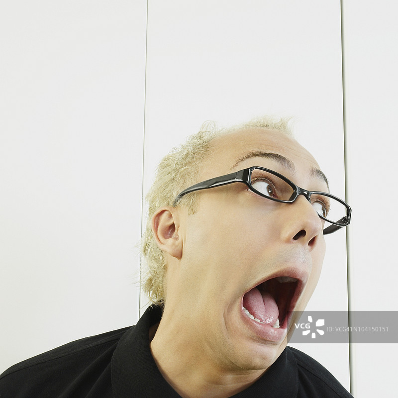 年轻男子大声喊叫并侧目而视的特写镜头图片素材