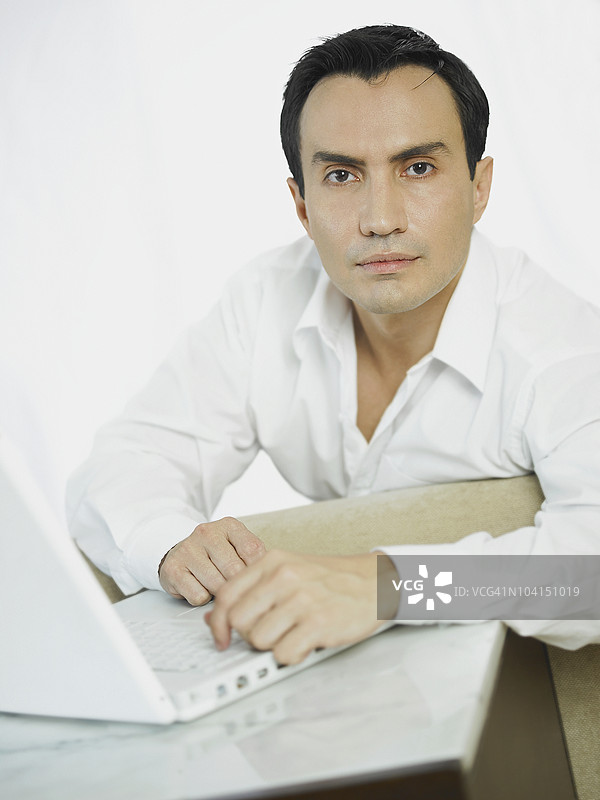 一位商人在笔记本电脑前的肖像图片素材