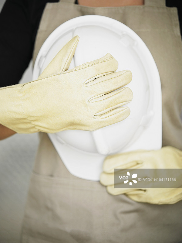 一个人手持安全帽的中部视图图片素材