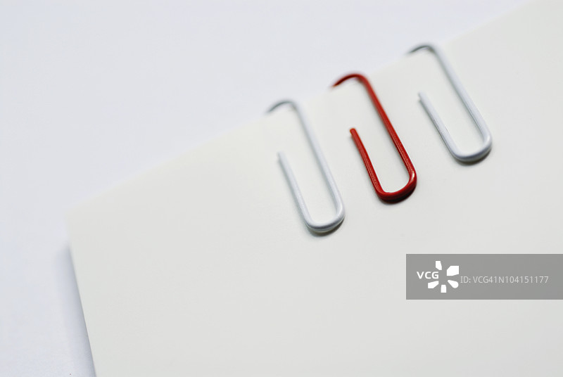 三只回形针在一张纸上的特写镜头图片素材