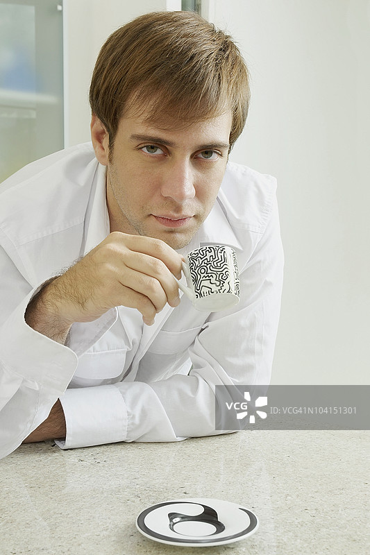 年轻男子手持咖啡杯的肖像图片素材