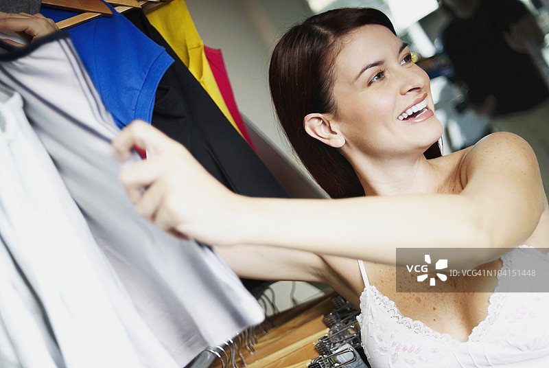 年轻女性在服装店挑选衣服的肖像图片素材