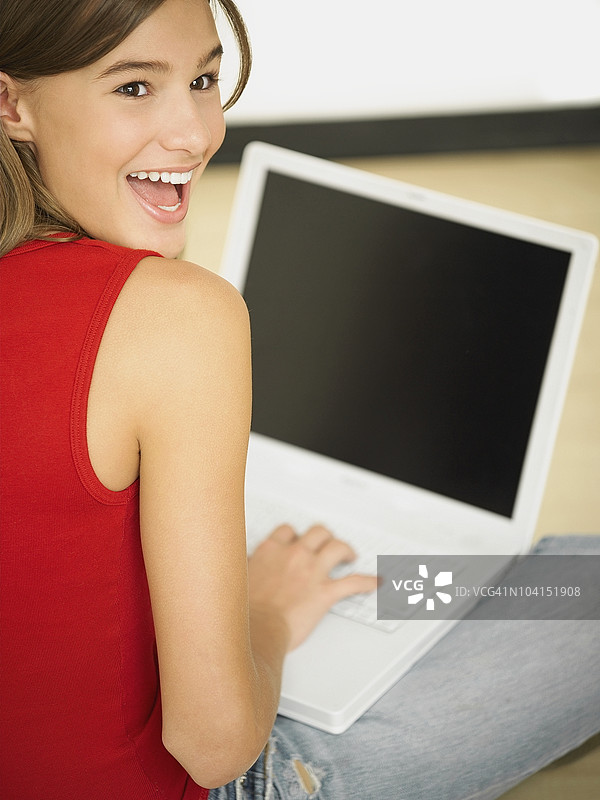 年轻女性使用笔记本电脑的背影图片素材