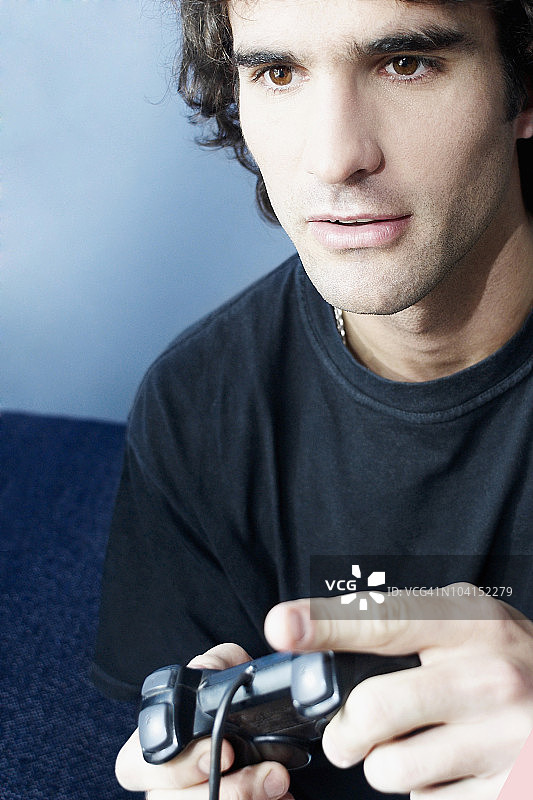 年轻男人玩电子游戏的特写图片素材