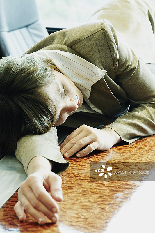 女商人在办公室的桌子上睡觉图片素材