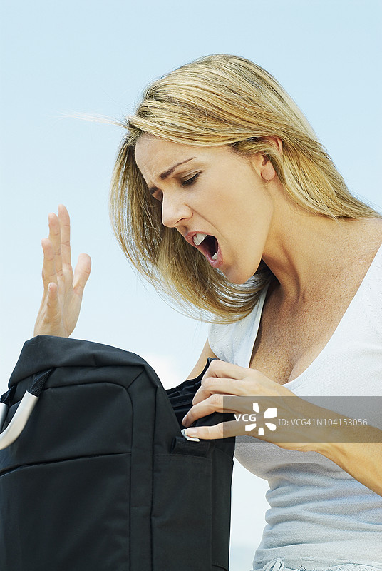 中年女性正在查看一个包并大声喊叫图片素材