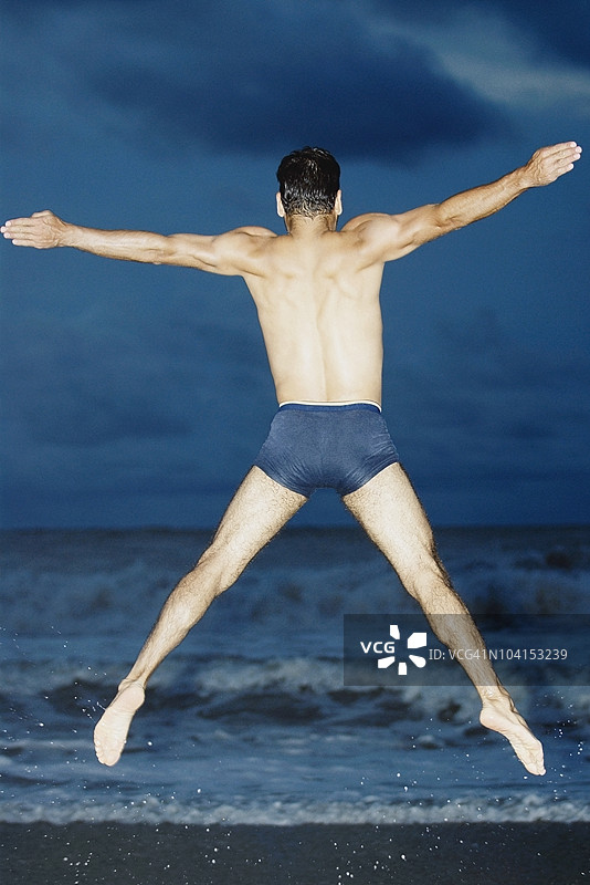中年男子在空中跳跃的背影图片素材