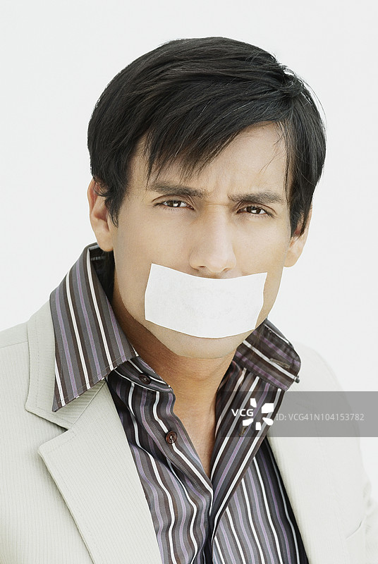 嘴上贴着绷带的年轻男子肖像图片素材