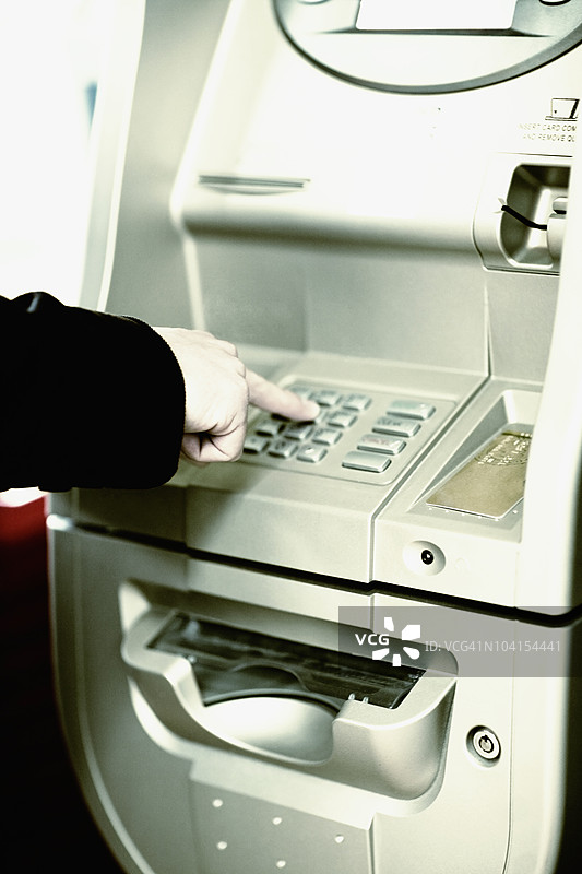 一个人手部特写正在操作自动取款机图片素材