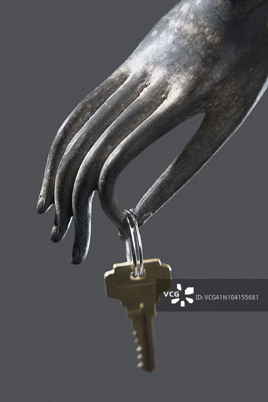 特写：拿着钥匙圈的金属雕塑图片素材