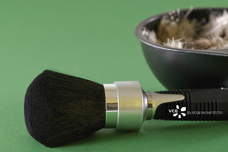 化妆刷的特写，旁边放着一碗羽毛图片素材