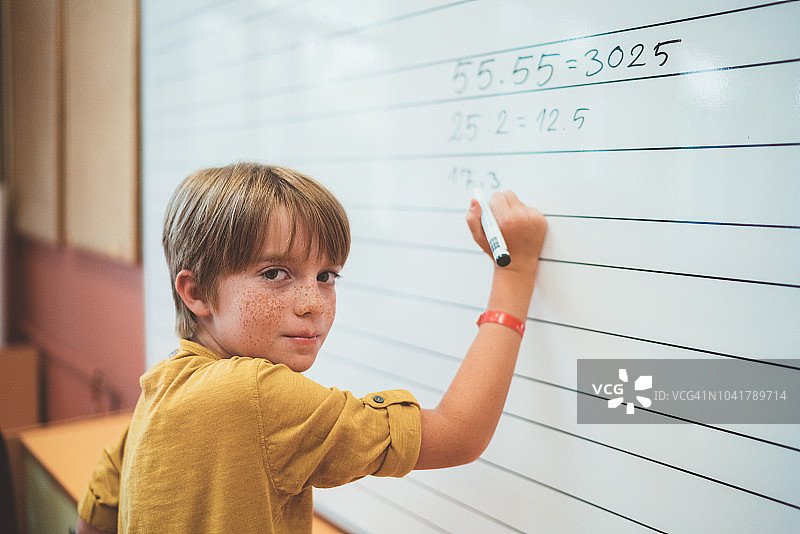 小学生在白板上解数学题图片素材