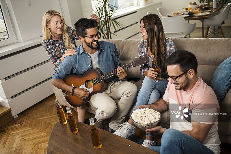 一起玩音乐、喝啤酒的快乐年轻人图片素材