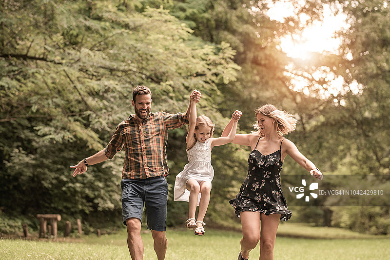 户外奔跑的年轻家庭图片素材