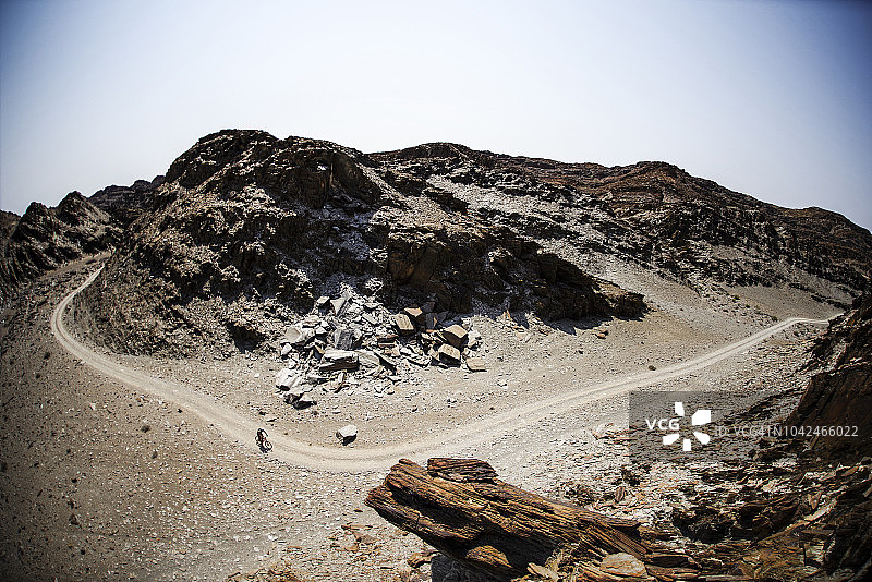 孤独的山地自行车手在纳米比亚纳米布沙漠的沙漠公路上图片素材