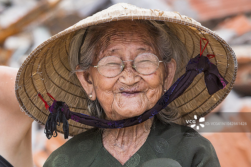 一位年长的当地妇女在Bai Xep休息时微笑，这是一个远离旅游路线的安静偏远渔村，距离归仁市10公里图片素材