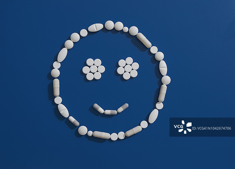 在蓝色背景上形成笑脸的药丸图片素材
