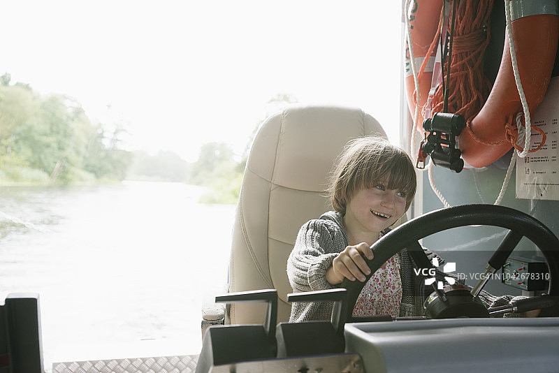 面带笑容的活泼小女孩骑着割草机图片素材