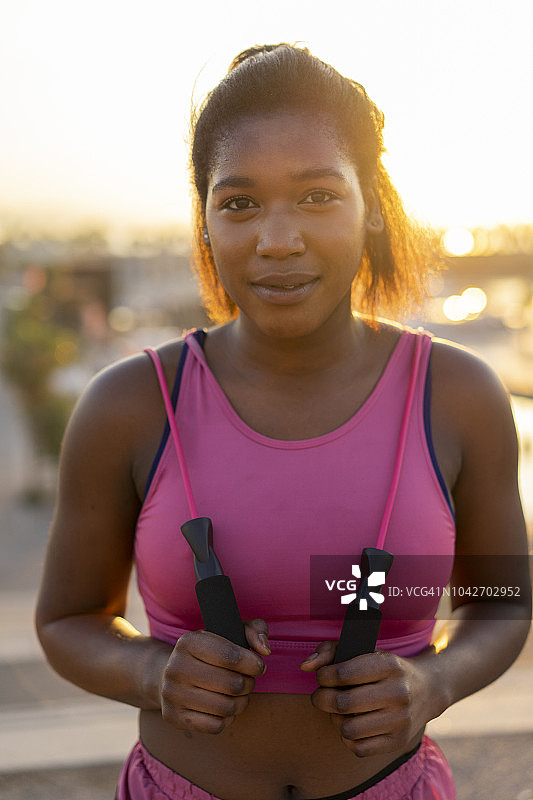 西班牙巴塞罗那：日出时拿着跳绳的年轻黑人女子图片素材